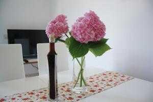 two vases with pink flowers on a table at Meri Apartment in Vodice