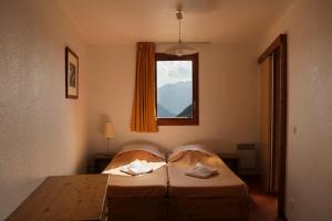 een slaapkamer met 2 bedden en een raam bij Résidence Les Bergers in L'Alpe-d'Huez
