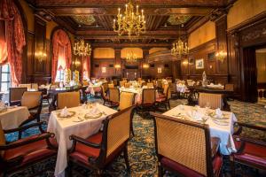 een restaurant met tafels en stoelen en een kroonluchter bij Hotel Du Pont in Wilmington