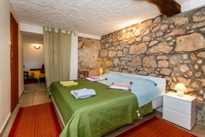 a bedroom with a bed and a stone wall at apartman SONJA in Risika