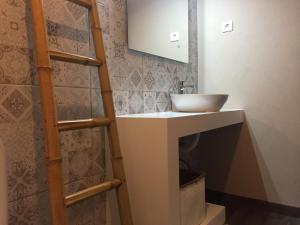 a bathroom with a sink and a mirror at The Lighthouse Apartment in Praia da Barra