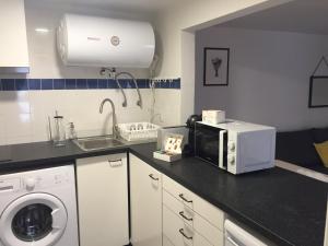 a kitchen with a microwave and a sink at Apartments Center Alfama in Lisbon