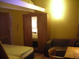 ルーヴェンにあるホイツォー ラファエルのベッド1台、ソファ、鏡が備わる客室です。