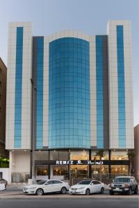 a large building with cars parked in front of it at Remaz Suites Hotel in Al Jubail