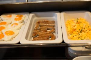 a tray of breakfast food with eggs sausage and potatoes at Hotel Heiligenstein in Baden-Baden
