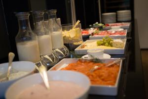 a table with plates of food and glasses of milk at Hotel Heiligenstein in Baden-Baden