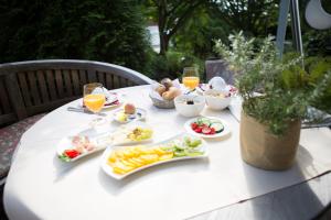 a table with plates of food and glasses of orange juice at Hotel Heiligenstein in Baden-Baden