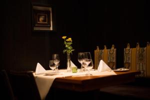 a table with wine glasses and a vase with flowers on it at Hotel Heiligenstein in Baden-Baden