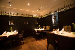 a dining room with tables and chairs and wine bottles at Hotel Heiligenstein in Baden-Baden