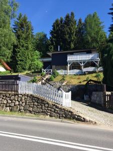 a house with a white picket fence next to a road at Babie Lato in Karpacz
