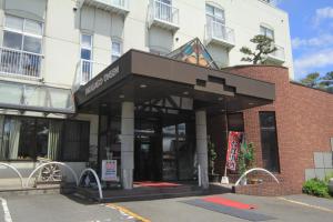 a building with a sign on the front of it at Takasago Onsen in Asahikawa