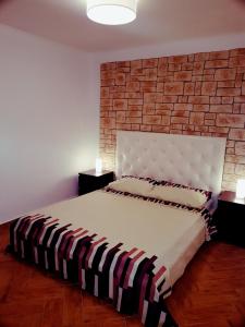 a bedroom with a bed with a brick wall at DolceFarNiente Fažana in Fažana