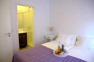 a white bed sitting next to a white table at Porto Smart Apartments- airport in Perafita