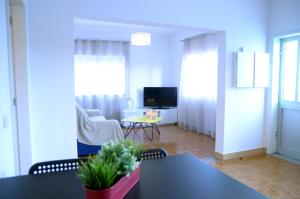 Porto Smart Apartments- airport في Perafita: غرفة معيشة مع طاولة وتلفزيون