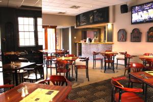 a restaurant with tables and chairs and a bar at Royal Hotel Ryde in Sydney