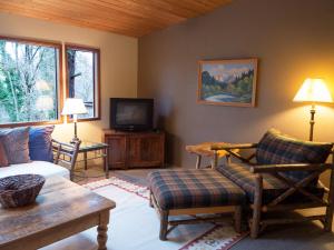 un soggiorno con divano e TV di The River House a Rogue River