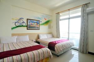 een slaapkamer met 2 bedden en een raam bij Lin Yuan Bicycle Homestay in Taitung