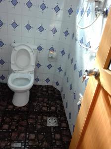 a bathroom with a toilet and a tile floor at Weligama Villa South in Weligama