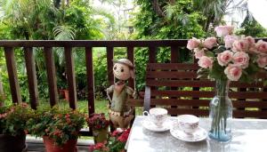 un tavolo con un vaso di fiori e una statua di Victoria B&B a Luodong