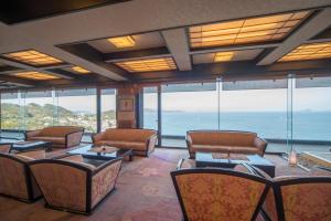 a waiting room with couches and tables and windows at Shinpachiya in Toba