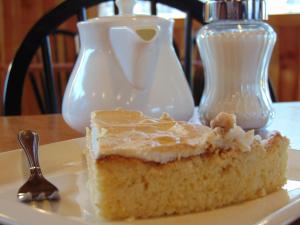 un trozo de pastel en un plato con una cuchara en Cafe & Hostal Acurruka, en Curacautín