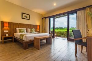 a hotel room with a bed and a balcony at Manyi Village Ubud in Ubud