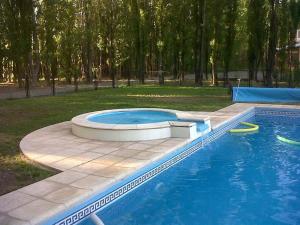 a swimming pool with two frisbees in a park at Terrazas En El Bosque Cabañas in Malargüe