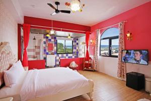 a bedroom with red walls and a bed with a tv at 綠島寧靜海潛水-城堡館 Twinkleocean diving hostel in Green Island