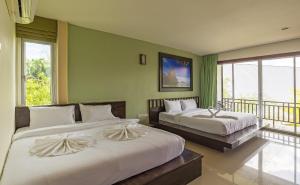 a bedroom with two beds and a balcony at Krabi Home Town Boutique in Krabi