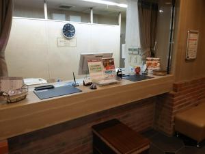 a reception counter in a waiting room with a mirror at Hotel Hyper Hills Hirosaki in Hirosaki