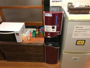 a kitchen with a microwave and a refrigerator at Oyado Hana in Nachikatsuura +14 photos