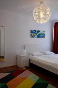 アルバ・ユリアにあるOlympus Apartmentのベッドルーム1室(ベッド1台、シャンデリア付)