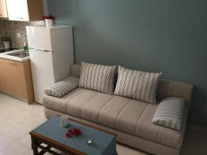 a living room with a brown couch and a refrigerator at Sea Sound in Vasiliki