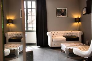 a living room with a couch and a table at Hotel Le Turenne in Beaulieu-sur-Dordogne