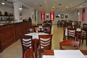 a restaurant with tables and chairs and a bar at Hotel Marub in Rubik