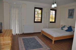 1 dormitorio con 1 cama y 2 ventanas en Hotel Marub en Rubik