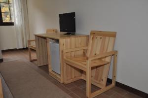 a room with a desk with a television and a chair at Hotel Marub in Rubik