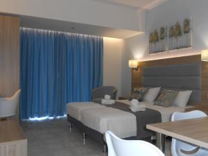 a hotel room with two beds and a table at Aristo Apts in Hersonissos