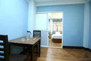 a dining room with a table and a bedroom at Aarya Chaitya Inn in Kathmandu