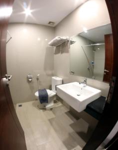 a bathroom with a sink and a toilet and a mirror at Urban Style by Front One in Margakaya