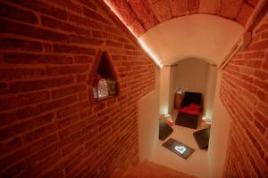 Zimmer mit Ziegelwand und einem Tisch mit Kerzen in der Unterkunft Tabano Ristorante-Casolare in Iesi