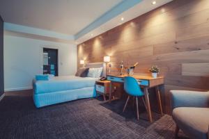 Crown Hotel Surry Hills في سيدني: غرفة في الفندق بها سرير ومكتب وسرير ومكتب