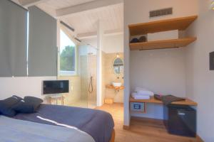 ein Schlafzimmer mit einem Bett und einem TV sowie ein Badezimmer in der Unterkunft Tabano Ristorante-Casolare in Iesi