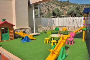 einen Spielplatz mit verschiedenen farbigen Spielgeräten im Hinterhof in der Unterkunft The Blue Lagoon Deluxe Hotel in Oludeniz