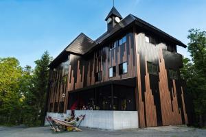 a large wooden building with a clock tower on top at Hotel Villa Hakuba by HHG in Hakuba