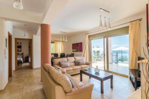 ein Wohnzimmer mit einem Sofa und einem Tisch in der Unterkunft Villa Inna in Mikros Gialos