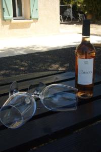 een paar glazen naast een fles wijn bij Le Petit Mas du Vigné in Saint-Pargoire