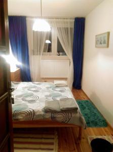 オストシツェにあるStamford Houseの小さなベッドルーム(青いカーテン付きのベッド1台付)