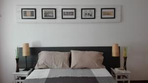 ローマにあるCinema Apartmentのベッドルーム1室(壁に3枚の写真が飾られたベッド1台付)