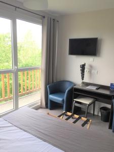 a living room with a desk and a balcony at Sweet Home Appart'Hôtel Deauville Sud in Deauville